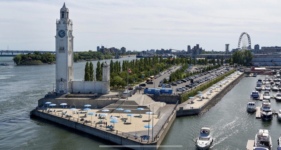 a water way with a parking lot and a clock tower